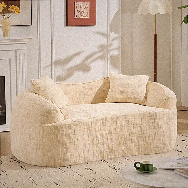 Beige curved two - person compress sofa. It has armrests on both sides, comes