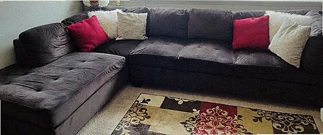 Left Facing Dark Brown Sectional Sofa With Pillows And Matching Area Rug