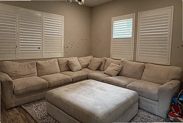 Sectional sofa with ottoman on the 1st floor. Black wood unit on the 3rd floor.